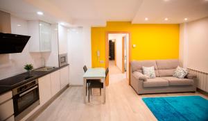 a kitchen and a living room with a couch and a table at Apartamentos Amaiur 2 in Estella