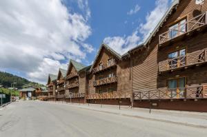 a row of wooden buildings on the side of a street at ZimaSnow Ski & Spa Club in Bukovel
