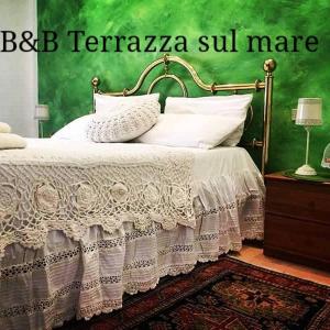 un letto in una camera da letto con parete verde di Terrazza sul Mare a Fano