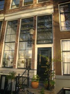 Cette grande maison dispose de grandes fenêtres et d'une porte. dans l'établissement Kalkmarkt Suites, à Amsterdam