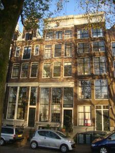 een gebouw waar auto's voor geparkeerd staan bij Kalkmarkt Suites in Amsterdam