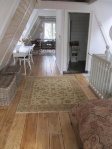 ein Wohnzimmer mit einer Treppe, einem Tisch und einem Teppich in der Unterkunft Kalkmarkt Suites in Amsterdam