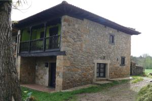 uma casa de pedra com uma varanda ao lado em La Casina de Celorio em Celorio