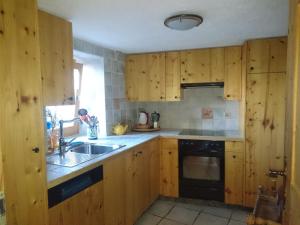 a kitchen with wooden cabinets and a sink at Gîte l'Ermitage in Veysonnaz