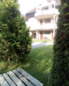 un banco de parque en el patio de una casa en Guest House Aleksandra en Bajina Bašta