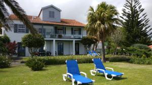 een huis met blauwe en witte stoelen in de tuin bij Vila Odette in Horta