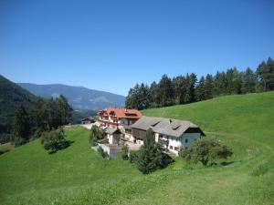 a house on a hill in a green field at Thalerhof in Perca