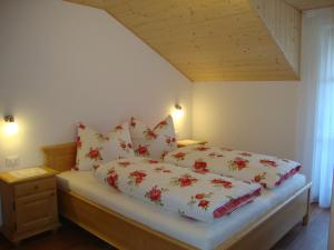 a bedroom with a bed with red and white pillows at Thalerhof in Perca