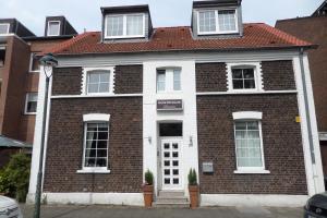 a red and white brick house with a red roof at Haus Gerry in Düsseldorf