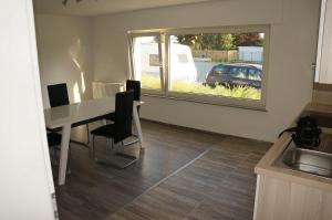 cocina con mesa, sillas y ventana en SoNi Apartment en Dieburg