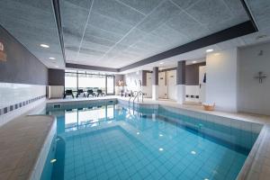 a large swimming pool in a building at Bilderberg Résidence Groot Heideborgh in Garderen