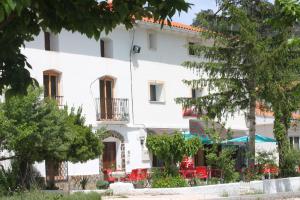 a white building with tables and chairs in front of it at Venta El Laminador in Riópar