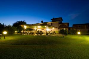 a group of people sitting in a yard at night at Locanda Bella Italia in Castelnuovo del Garda