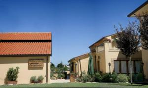 a couple of buildings with a sign in a yard at Angelucci Agriturismo con Camere e Agri Camping in Lanciano