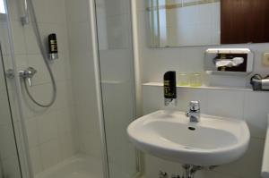 a bathroom with a sink and a shower at G&H Hotel Rosengarten in Rosengarten +71 photos