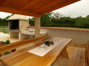 a wooden deck with a table and a pizza oven at Kuća Renata in Pula