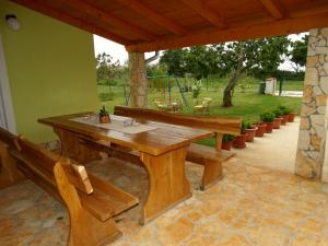 una mesa de madera y bancos en un patio en Kuća Renata en Pula
