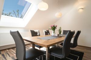 une salle à manger avec une table en bois et des chaises noires dans l'établissement MA-LIVING Miralior Apartment Mainz, à Mayence