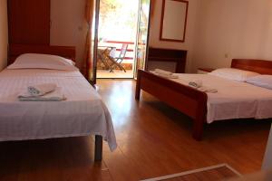 two beds in a room with wooden floors at Pension Tamaris in Sveta Nedelja