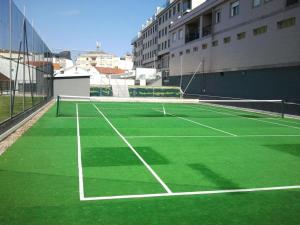 einen Tennisplatz mit grünem Gras drauf in der Unterkunft Apartamento Playa Mar Portonovo Centro. in Sanxenxo
