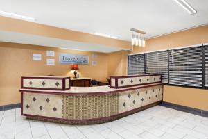 a hotel lobby with a waiting area with a traveler sign at Travelodge by Wyndham Reno in Reno
