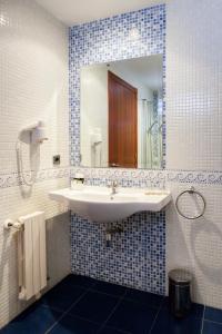 ein Bad mit einem Waschbecken und einem Spiegel in der Unterkunft Hotel Valencia in Ferrol