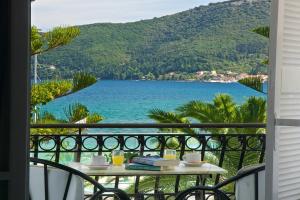 a table on a balcony with a view of the water at Hotel Athina in Karavomylos