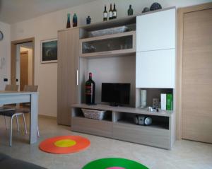 Appartamento Berlicche في Agliana: غرفة معيشة مع زجاجة من النبيذ على رف
