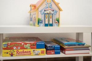 a toy house sitting on top of books on a shelf at Miralior Apartment Mainz - perfekt für Business, Familie, Weinproben im Herbst! in Mainz