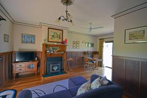 a living room with a couch and a fireplace at Araluen Park Cottages in Lakes Entrance