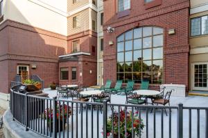a patio with tables and chairs in front of a brick building at Aspen Suites - Rochester in Rochester