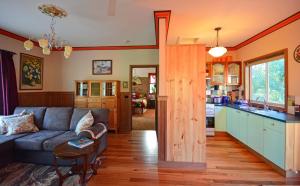 a living room with a couch and a kitchen at Araluen Park Cottages in Lakes Entrance