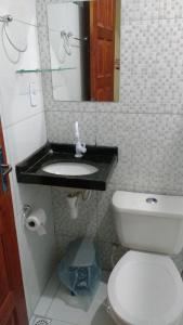 a bathroom with a toilet and a sink with a mirror at Pousada Brisa de Flecheiras in Flecheiras