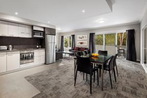 a kitchen and dining room with a table and chairs at Quest Campbelltown in Campbelltown