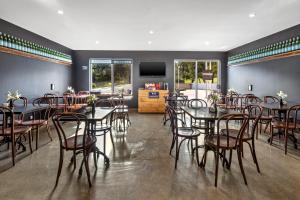 une salle à manger avec des tables et des chaises et une télévision à écran plat dans l'établissement Quest Campbelltown, à Campbelltown