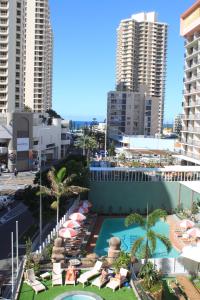 um resort com piscina, cadeiras e edifícios em Bunk Surfers Paradise International Backpacker Hostel em Gold Coast