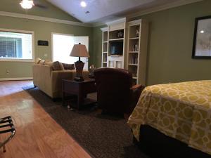 Mayfield的住宿－Southern Comfort Suites，一间卧室配有一张床、一张沙发和一把椅子