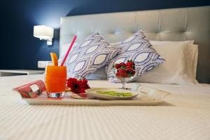 a tray of food and a drink on a bed at RochaBay Apartment in Portimão