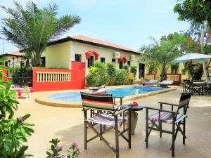 a patio with two chairs and a swimming pool at Kingfishers Apartments in Bijilo