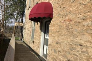 a red umbrella hanging from a brick wall at Cheltenham Suites in Caledon