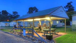 a large pavilion with people sitting in the grass at Eden Gateway Holiday Park in Eden