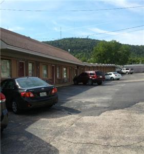 um parque de estacionamento com carros estacionados em frente a um edifício em Shamrock Motel Hot Springs em Hot Springs