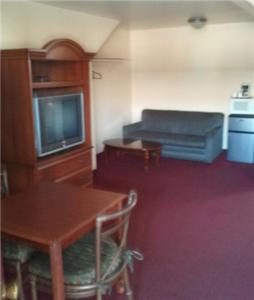 Habitación con mesa, TV, mesa y silla. en Shamrock Motel Hot Springs, en Hot Springs