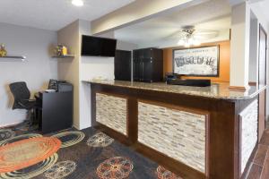 a kitchen with a bar in a hotel room at Super 8 by Wyndham Janesville in Janesville