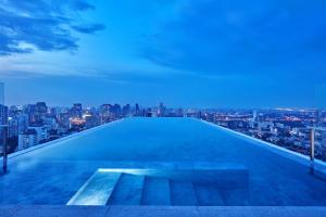 a swimming pool on top of a building with a city skyline at 137 Pillars Suites Bangkok in Bangkok