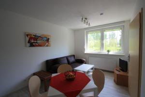 a living room with a couch and a table at Pension vorm Darß in Hirschburg