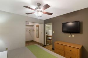 a bedroom with a ceiling fan and a flat screen tv at Studio 6-Lubbock, TX - Medical Center in Lubbock