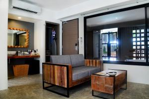 a living room with a chair and a table at Deevana Krabi Resort in Ao Nang Beach