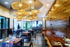 a dining room with tables and chairs and chandeliers at Deevana Krabi Resort in Ao Nang Beach