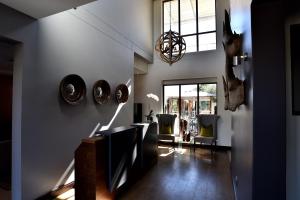 uma sala de estar com televisão e cadeiras em Tredenham Boutique Hotel em Bloemfontein